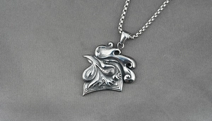 Detailed close-up of a vintage rooster head pendant on a sturdy metal box chain