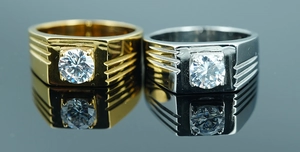 Close-up of gold and silver men's titanium steel rings with central diamond inlay and grooved sides