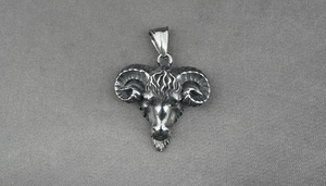 Detailed view of vintage silver ram head pendant with spiral horns and antique finish