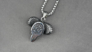 Macro detail of stainless steel ram head pendant with engraved mystical runes and box chain