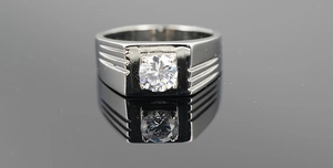 Close-up of men's steel signet ring with a round center stone and parallel side grooves