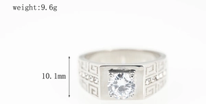 Macro shot of silver titanium ring with Greek key pattern and clear center stone