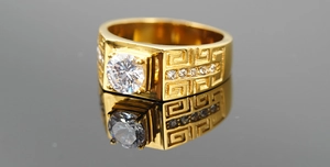 Close-up of gold titanium ring with Greek meander pattern and large round centerpiece