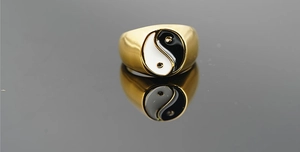 Detailed close-up of wide gold titanium ring featuring a black and white Yin Yang symbol