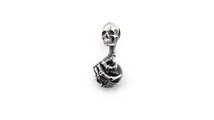 Close-up of gothic skull pendant with skeletal hand holding a black gemstone bead