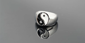 Macro shot of polished stainless steel ring featuring a black and white Tai Chi Yin Yang symbol