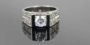 Macro detail of silver titanium steel ring with meander pattern and cz center stone
