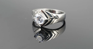 Detail view of titanium steel wedding ring featuring a round diamond and V-shaped engravings