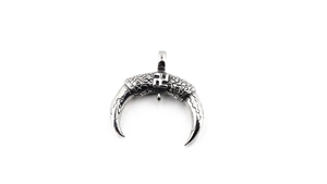 Détail macro du pendentif croissant vintage avec motifs gaufrés en finition argentée