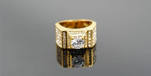 Détail d'une bague large plaquée or avec pierre centrale et pavage de zircons blancs