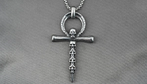 Detail of gothic ankh cross pendant with skulls made of vintage silver titanium steel