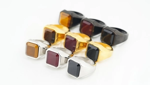 Nahaufnahme von neun quadratischen Siegelringen in Silber, Gold und Schwarz mit Steinen