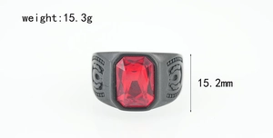 Vista macro de anillo ancho de metal negro con piedra roja de corte esmeralda