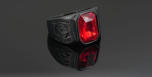 Macro de una gema roja rectangular en un anillo vintage negro mate con relieve lateral