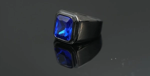 Vista macro de anillo ancho negro para hombre con piedra rectangular azul facetada