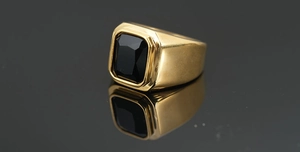 Primer plano de un anillo bañado en oro con ónice negro rectangular y acabado pulido