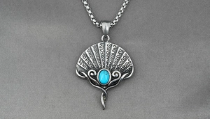 Detailed close-up of retro fan-shaped pendant with blue turquoise inlay on a steel chain
