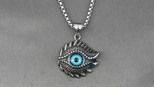 Macro shot of titanium steel evil eye pendant with blue eyeball and dragon scale texture