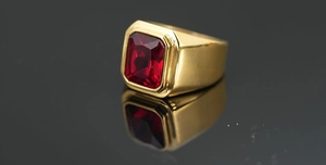 Primer plano macro de un anillo ancho de oro con una gran gema roja de corte rectangular incrustada
