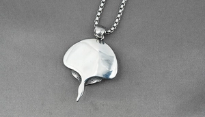 Macro shot of silver stingray pendant with polished surface and steel box chain