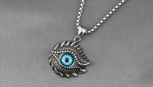 Macro shot of silver dragon eye pendant with blue pupil and textured box chain details