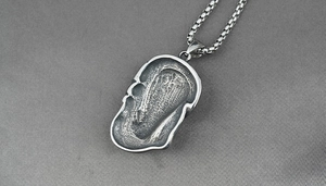 Gros plan détaillé du pendentif tête de mort rétro en acier titane oxydé texturé vintage