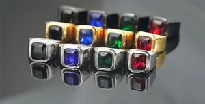 Detalle de anillos con gema rectangular en acabados plata, dorado y negro metálico