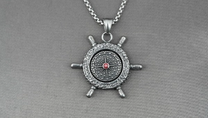 Makroansicht der Vintage-Steuerrad-Halskette mit zentralem rotem Edelstein-Inlay