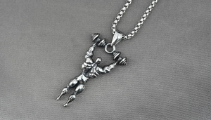 Détail macro du pendentif de fitness musclé avec haltères sur chaîne en acier