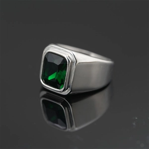 Anillo de sello en plata pulida con gema verde rectangular sobre un fondo negro liso