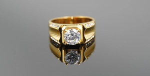 Macro detail of men's gold plated titanium ring featuring a large zircon and side crystals