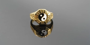 Macro shot of gold Tai Chi Bagua ring with polished octagon face and vintage relief details