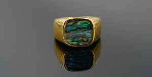 Detailed close-up of a vintage titanium steel ring with iridescent abalone shell inlay