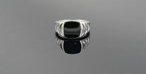 Macro shot of silver signet ring with square black enamel inlay and textured vertical grooves