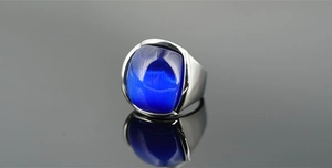 Macro di un anello in acciaio al titanio argento con pietra occhio di gatto blu quadrata