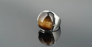 Macro dettaglio di un anello vintage da uomo in acciaio al titanio con occhio di gatto