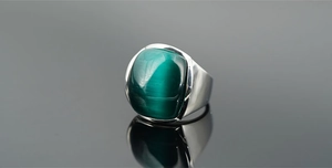 Dettaglio macro di pietra occhio di gatto verde incastonata in anello d'argento lucido