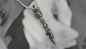Detailed close-up of a vintage titanium steel vajra pestle pendant with dragon head design