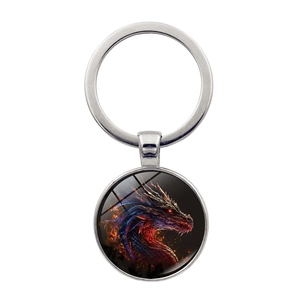 Detailaufnahme runder Metall-Schlüsselanhänger mit Feuerdrachen-Motiv unter Glas