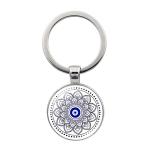 Detail of evil eye glass pendant keychain with intricate black mandala flower patterns