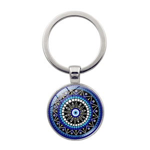 Macro detail of Evil Eye glass pendant with mandala pattern on silver metal keychain