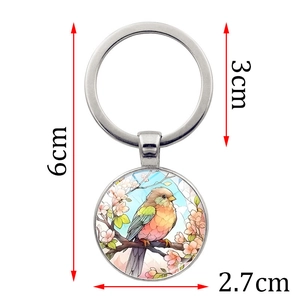 Porte-clés cabochon en verre colibri avec anneau en métal argenté et décor de fleurs