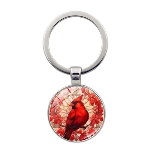 Détail d'un porte-clés en métal avec un motif colibri coloré sur un pendentif rond