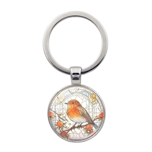 Détail du porte-clés colibri en verre avec baies rouges sur anneau métallique argenté