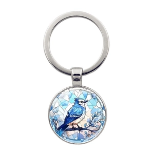 Gros plan détaillé d'un porte-clés argenté avec un pendentif en verre d'art mésange bleue