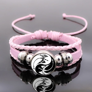 Pink braided leather bracelet with Yin Yang Dragon glass cabochon on reflective black background