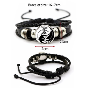 Macro detail of multilayer woven leather bracelet with Yin Yang dragon glass dome charm