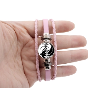 Detail of pink layered braided leather bracelet with Yin Yang dragon glass pendant
