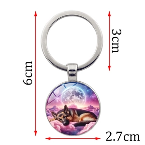 Sleeping German Shepherd keychain featuring round metal pendant with galaxy moon design