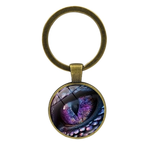 Mystic dragon eye keychain with glass cabochon and antique bronze metal ring on white background